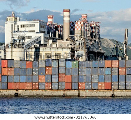 GENOA, ITALY - SEPTEMBER 24, 2015: the coal power plant of the Enel in Genoa port. Containers and silos on the dock in front of the power plant.