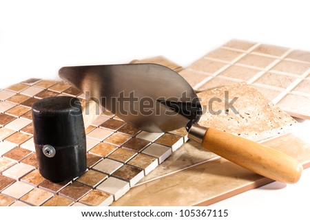 Mosaic of colored marble, rubber mallet and trowel for laying ceramic tile