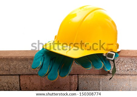 Yellow hard hat and a brick wall on a white background