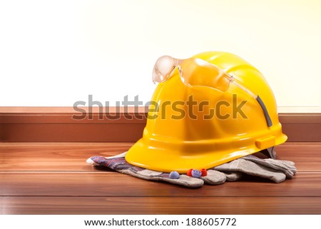 Yellow hard hat, gloves on the wooden floor