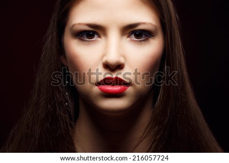 Portrait of young beautiful modern woman model looks, Face close up. Studio photo portrait. Beautiful woman with brown eyes and bright red lips. Makeup. Female model - the concept of modern fashion.