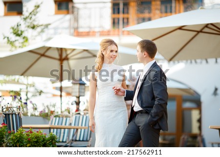 Young beautiful couple, man and woman bride groom walk up the stairs. Wedding walk in the courtyard of the restaurant. The broader perspective of the frame.