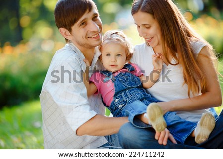 Happy family of three people relaxing in a city park. Happy family concept of the good life
