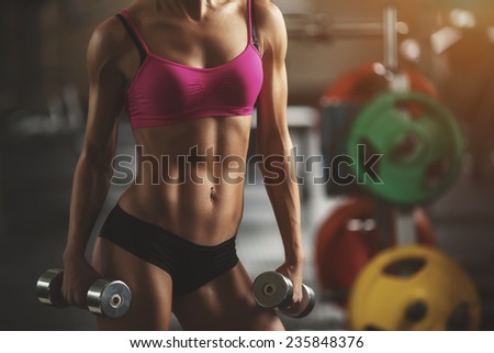 Brutal athletic woman pumping up muscles with dumbbells. Part of body. Attractive fitness woman, trained female body, lifestyle portrait, caucasian model