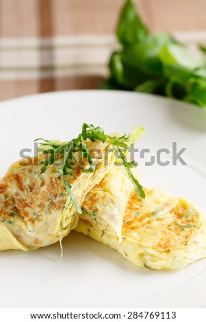 Close-up of scrambled eggs with arugula on white dish