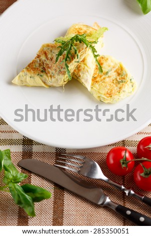 Close-up of scrambled eggs with arugula on white dish