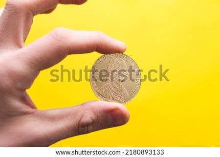 the man holds a gold bullion coin. Four ducats. Investing in gold Photo stock © 