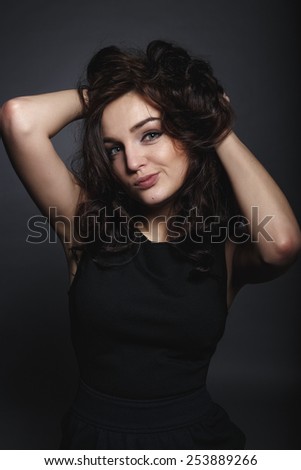 Happy girl excited. Young woman smiling very happy surprised holding head being amazed on grey background. Funky young Caucasian female model joyful on grey background.