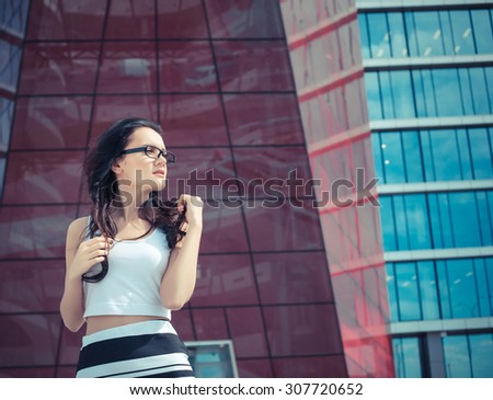 Beautiful business woman on the background of the modern office near the sport car