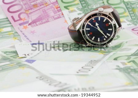Luxury watch on background full of money