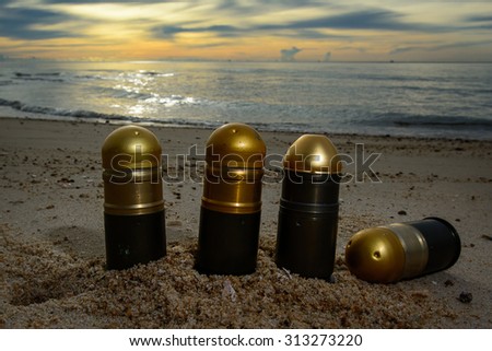 Explosive shell size 40 mm. / Ammunition, a grenade launcher / On the beach at sunrise