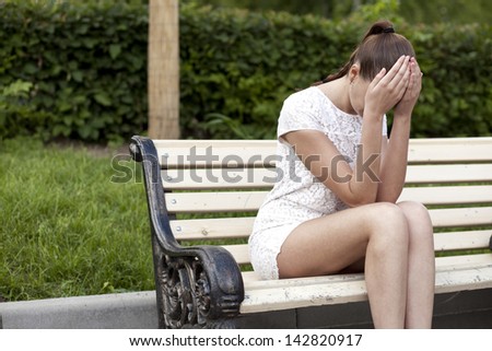 Sad young woman sitting on bench