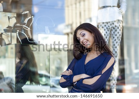 Young woman looking at shop window boutique