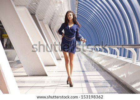 Full length portrait of a beautiful woman walking in blue dress