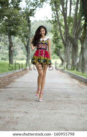 Full growth,  beautiful young woman in color dress