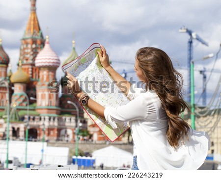Young beautiful girl holding a tourist map of Moscow, Russia
