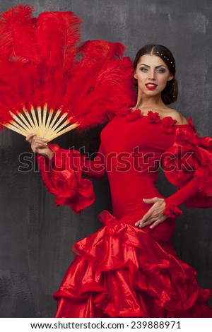 Sexy Woman traditional Spanish Flamenco dancer dancing in a red dress with fan