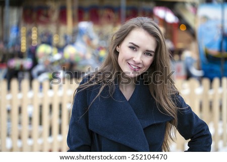 Young beautiful woman in stylish dark gray wool coat on a background of a winter street