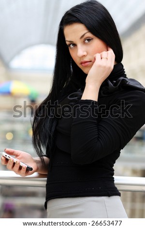 The young girl holds a cellular telephone in hands