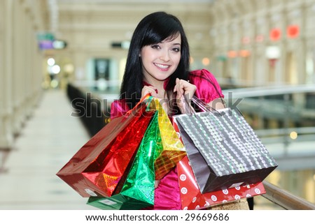 portrait of one happy young adult girl with colored bags