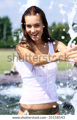 Heat. The young woman bathes in a city fountain