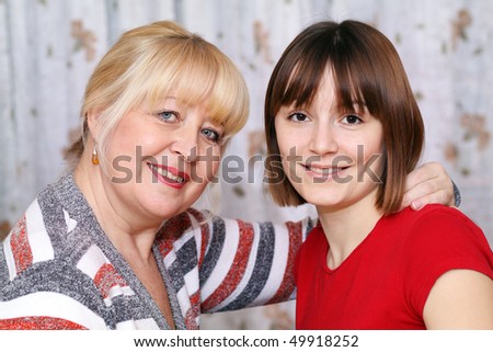 young happy woman huggs an older happy elderly women