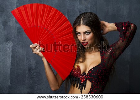 Sexy Woman traditional Spanish Flamenco dancer dancing in a red dress with fan