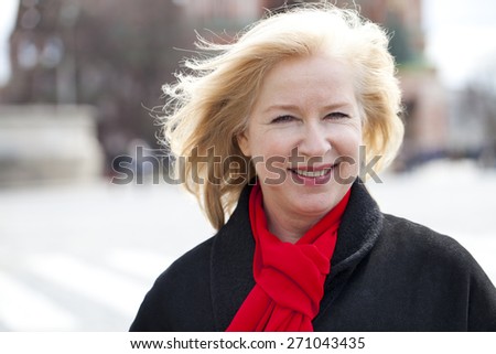 Happy portrait of an elderly blonde woman, spring on the street