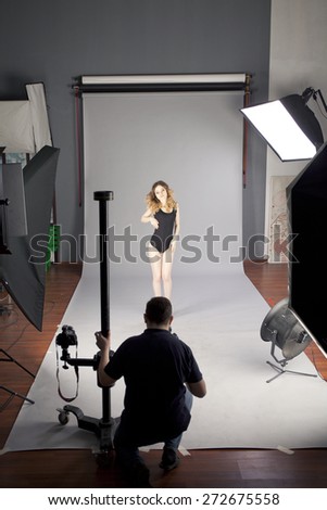 Working conditions in the studio, the photographer photographs the professional model