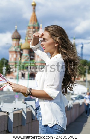 Young beautiful blonde girl holding a tourist map of Moscow, Russia