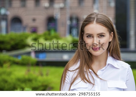 Young beautiful business woman in white shirt on summer street