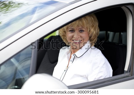 Beautiful old happy elderly driver woman 55-60 years in jacket Driving a Car