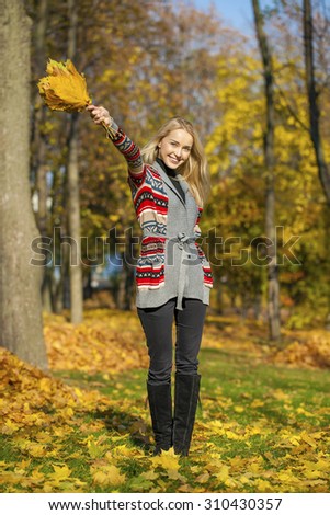 Young Beautiful blonde woman walks in autumn park