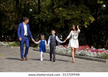 Young happy family walking in autumn park