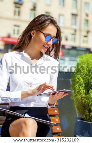 Young beautiful business woman reading notepad