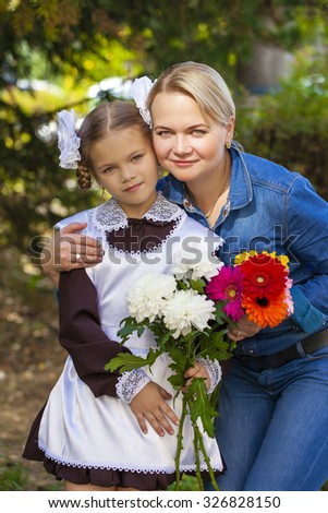Close up portrait of a beautiful nine year old little girl and happy mother in autumn park
