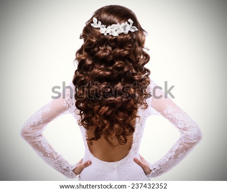 picture of long curly brown hair.brunette girl in white wedding dress with a low-cut back