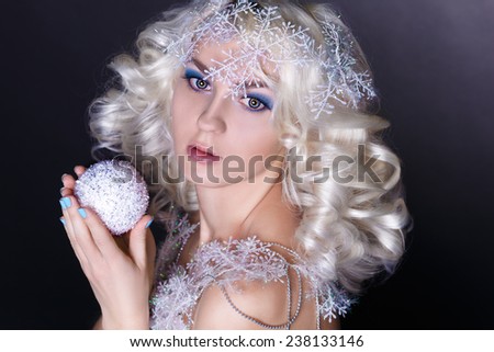 Portrait of snow queen.Winter Beauty Woman. Christmas Girl Makeup. Holiday Make-up. Snow Queen High Fashion Portrait over Blue Snow Background.