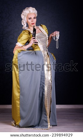 beautiful haughty queen in royal clothing with pearls and with a gun in hands