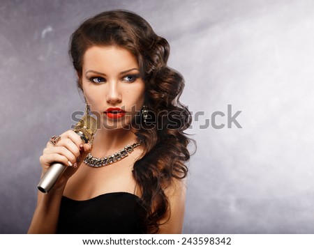 Singing Woman with Microphone. Beauty Glamour Singer Girl. Vintage Style. Song.Portrait of a glamorous girl holding a mike and singing
