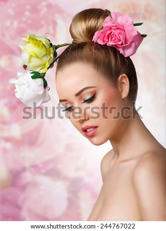 Fashion Beauty Model Girl with Rose Flowers Hair. Make up and Hair Style. Hairstyle. Nude makeup. Bouquet of Beautiful Flowers on lady\'s head.on a pink floral background