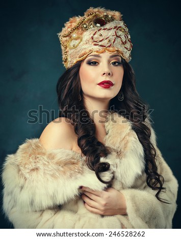 Beautiful haughty queen in royal dress. sexy girl in royal hat and fur coat