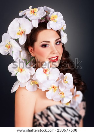 Fashion Beauty Model Girl with Orchid Flowers Hair. Bouquet of Beautiful Flowers on lady\'s head.Fashion Art