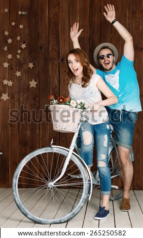 Couple sitting on the one bike hugging and smiling.Two young people man and woman full of emotion sitting on the bike.girl lucky guy on a bike