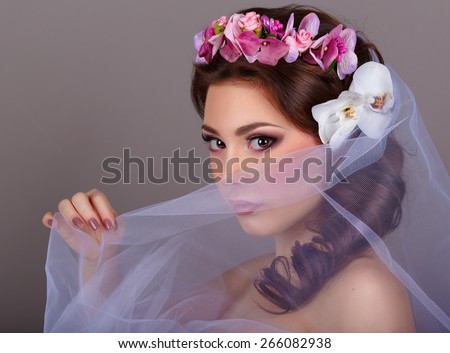girl covers the face veil.girl with orchids flower in her hair. Professional Make-up.Makeup. Fashion Art.Hairstyle with flowers. Fantasy girl portrait .