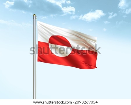 Greenland flag waving on blue sky background with clouds. Close up waving flag of Greenland. Greenland flag waving in the wind.
