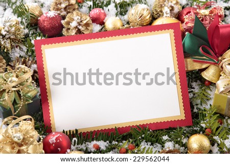 Blank Christmas card or invitation with red envelope surrounded by decorations. Space for copy.