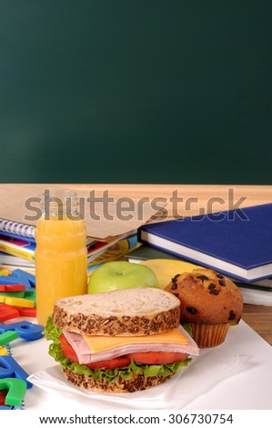 School lunch on classroom desk with blackboard, copy space