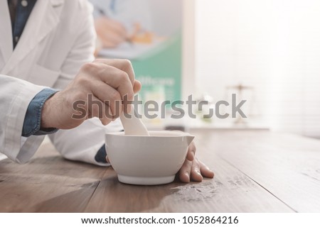Professional pharmacist grinding a medical preparation using a mortar and pestle, pharmacy and medicine concept, hands close up Foto stock © 