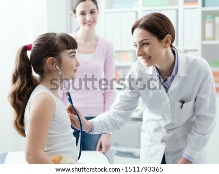 Female doctor examining a cute smiling girl with a stethoscope, the mother is next to her, children and healthcare concept ストックフォト © 